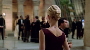 Movie still from “A Perfect Murder” (1998), directed by Andrew Davis – A woman in a red dress standing in front of a crowd of people; Medium shot, Over the shoulder angle