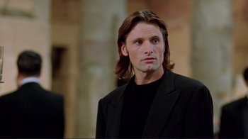 Movie still from “A Perfect Murder” (1998), directed by Andrew Davis – A person with long hair wearing a suit; Close Up shot, Over the shoulder angle