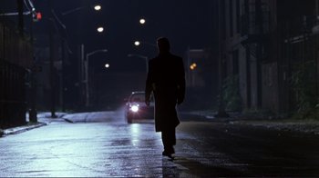 Movie still from “A Perfect Murder” (1998), directed by Andrew Davis – A man walking down a street at night; Wide shot, Low angle