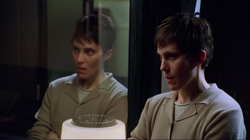 Movie still from “A Perfect Murder” (1998), directed by Andrew Davis – A woman looking in the mirror in front of a lamp; Close Up shot, Over the shoulder angle