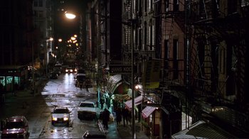 Movie still from “A Perfect Murder” (1998), directed by Andrew Davis – People walking down a street at night in the rain; Extreme Wide shot, High angle