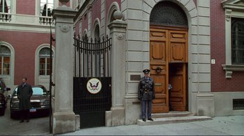 Movie still from “A Perfect Murder” (1998), directed by Andrew Davis – A man in uniform standing in front of an entrance to a building; Wide shot, Low angle