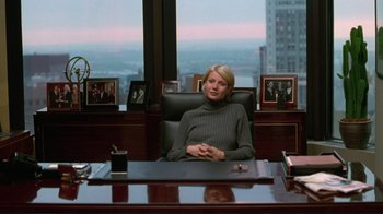 Movie still from “A Perfect Murder” (1998), directed by Andrew Davis – A woman sitting at a desk in an office setting; Medium shot, Over the shoulder angle