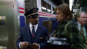 Movie still from “A Perfect Murder” (1998), directed by Andrew Davis – A man in a train conductor's uniform talking to a man in front of a train; Medium shot, Over the shoulder angle