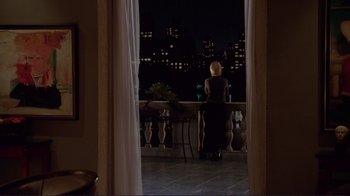 Movie still from “A Perfect Murder” (1998), directed by Andrew Davis – A woman standing on a balcony at night looking at the city lights; Wide shot, High angle