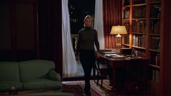 Movie still from “A Perfect Murder” (1998), directed by Andrew Davis – A woman walking in front of a living room door; Wide shot, High angle