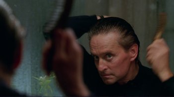 Movie still from “A Perfect Murder” (1998), directed by Andrew Davis – A man in a black shirt is holding a sword; Close Up shot, Over the shoulder angle