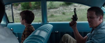 Movie still from “A Perfect World” (1993), directed by Clint Eastwood – Two people sitting in a car looking out the window; Medium shot, Over the shoulder angle