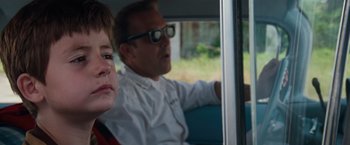 Movie still from “A Perfect World” (1993), directed by Clint Eastwood – A man and a boy sitting in the back of a car; Close Up shot, Over the shoulder angle