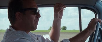 Movie still from “A Perfect World” (1993), directed by Clint Eastwood – A man in a white shirt is holding a cigarette in his hand; Close Up shot, Over the shoulder angle