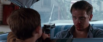 Movie still from “A Perfect World” (1993), directed by Clint Eastwood – Two people sitting in the back of a car; Close Up shot, Over the shoulder angle