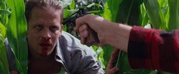 Movie still from “A Perfect World” (1993), directed by Clint Eastwood – A man with a gun pointed at another man with a gun pointed at him; Close Up shot, Over the shoulder angle