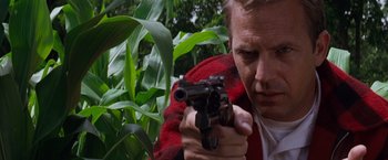 Movie still from “A Perfect World” (1993), directed by Clint Eastwood – A man holding a gun in his hands; Close Up shot, Low angle