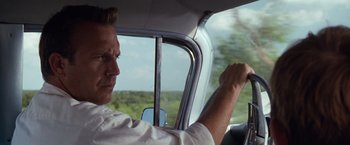 Movie still from “A Perfect World” (1993), directed by Clint Eastwood – A man sitting in the driver's seat of a car; Close Up shot, Over the shoulder angle