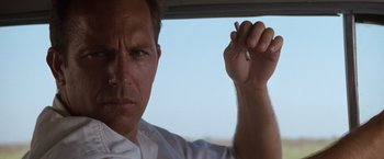 Movie still from “A Perfect World” (1993), directed by Clint Eastwood – A person in a car holding a cigarette; Close Up shot, Low angle