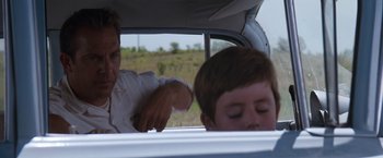 Movie still from “A Perfect World” (1993), directed by Clint Eastwood – A man and a child in a car; Close Up shot, Over the shoulder angle