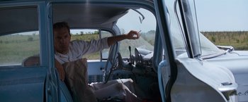 Movie still from “A Perfect World” (1993), directed by Clint Eastwood – A man holding a cigarette in the driver's seat of a truck; Medium shot, Low angle