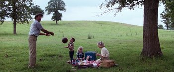 Movie still from “A Perfect World” (1993), directed by Clint Eastwood – A woman and two children playing with a ball in a field; Wide shot, Low angle