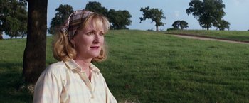 Movie still from “A Perfect World” (1993), directed by Clint Eastwood – A woman standing in a field with trees in the background; Close Up shot, Low angle