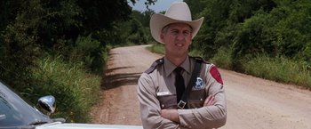 Movie still from “A Perfect World” (1993), directed by Clint Eastwood – A man in a cowboy hat standing in front of a dirt road; Close Up shot, Over the shoulder angle
