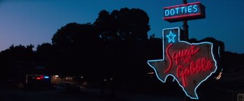 Movie still from “A Perfect World” (1993), directed by Clint Eastwood – A neon sign in the shape of the state of texas at night; Wide shot, Low angle