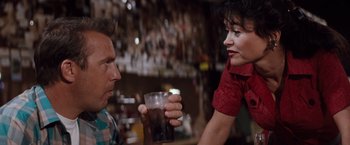 Movie still from “A Perfect World” (1993), directed by Clint Eastwood – A man and a woman are holding a glass of soda; Close Up shot, Over the shoulder angle