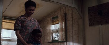 Movie still from “A Perfect World” (1993), directed by Clint Eastwood – A man and a child in a room with curtains; Medium shot, Low angle