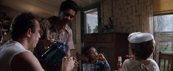 Movie still from “A Perfect World” (1993), directed by Clint Eastwood – A man and a boy are sitting at a dining table; Medium shot, Over the shoulder angle