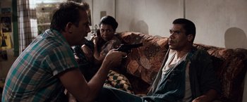 Movie still from “A Perfect World” (1993), directed by Clint Eastwood – A man holding a gun pointed at another man; Medium shot, Over the shoulder angle