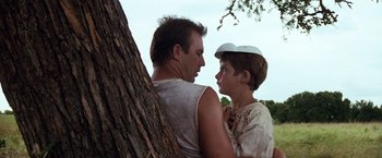 Movie still from “A Perfect World” (1993), directed by Clint Eastwood – A man and a boy standing next to a tree; Medium shot, Low angle