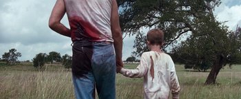 Movie still from “A Perfect World” (1993), directed by Clint Eastwood – A man and a boy holding hands in a field; Medium shot, Low angle