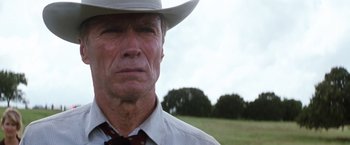 Movie still from “A Perfect World” (1993), directed by Clint Eastwood – An older man wearing a cowboy hat in a grassy field; Close Up shot, Low angle