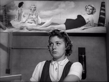 Movie still from “A Place in the Sun” (1951), directed by George Stevens – A woman in front of a picture of a pin - up girl; Medium shot, Low angle