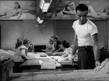 Movie still from “A Place in the Sun” (1951), directed by George Stevens – A black and white photo of a man standing in front of a table; Wide shot, Low angle