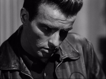 Movie still from “A Place in the Sun” (1951), directed by George Stevens – Black and white photograph of a man in a leather jacket; Close Up shot, Low angle
