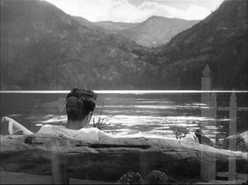 Movie still from “A Place in the Sun” (1951), directed by George Stevens – A man sitting on a bench looking out over a lake; Extreme Wide shot, High angle