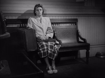 Movie still from “A Place in the Sun” (1951), directed by George Stevens – A woman sitting on top of a wooden bench; Wide shot, High angle