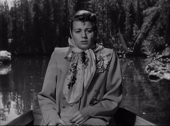 Movie still from “A Place in the Sun” (1951), directed by George Stevens – A woman sitting in a boat on a river; Medium shot, Low angle