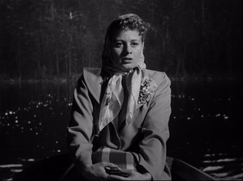Movie still from “A Place in the Sun” (1951), directed by George Stevens – A woman sitting in front of a body of water; Medium shot, Low angle