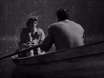 Movie still from “A Place in the Sun” (1951), directed by George Stevens – A man and a woman sitting in a boat on a lake; Medium shot, High angle