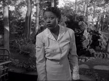 Movie still from “A Place in the Sun” (1951), directed by George Stevens – A black and white photo of a woman standing in front of trees; Medium shot, Low angle