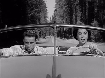 Movie still from “A Place in the Sun” (1951), directed by George Stevens – A man and a woman sitting in the back seat of a car; Medium shot, Low angle