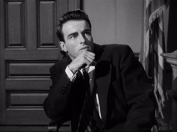 Movie still from “A Place in the Sun” (1951), directed by George Stevens – Black and white photograph of a man wearing a suit and tie; Close Up shot, Low angle