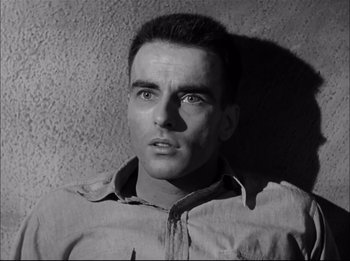 Movie still from “A Place in the Sun” (1951), directed by George Stevens – Black and white photograph of a man in a tan shirt; Close Up shot, High angle