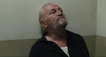 Movie still from “A Prophet” (2009), directed by Jacques Audiard – An older man with a beard and a white mustache; Close Up shot, Low angle