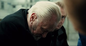 Movie still from “A Prophet” (2009), directed by Jacques Audiard – An older man with white hair and a goatee; Close Up shot, Over the shoulder angle
