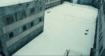 Movie still from “A Prophet” (2009), directed by Jacques Audiard – An aerial view of a soccer field in the middle of the snow; Extreme Wide shot, High angle