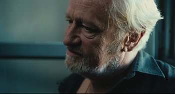 Movie still from “A Prophet” (2009), directed by Jacques Audiard – An older man with a beard looking to his left; Close Up shot, Over the shoulder angle