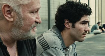 Movie still from “A Prophet” (2009), directed by Jacques Audiard – A man with a beard and a man with a mustache; Close Up shot, Over the shoulder angle