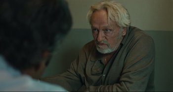 Movie still from “A Prophet” (2009), directed by Jacques Audiard – An older man sitting in front of another older man; Close Up shot, Over the shoulder angle